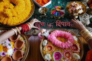 Celebratory Diwali table adorned with flowers, garlands, and traditional Indian sweets.